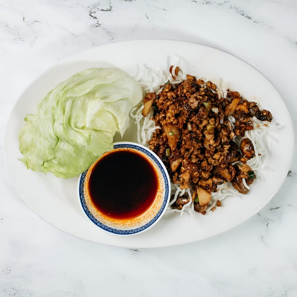 Vinsar's Lounge Asian-fusion lettuce wraps with minced meat, noodles, and dipping sauce.